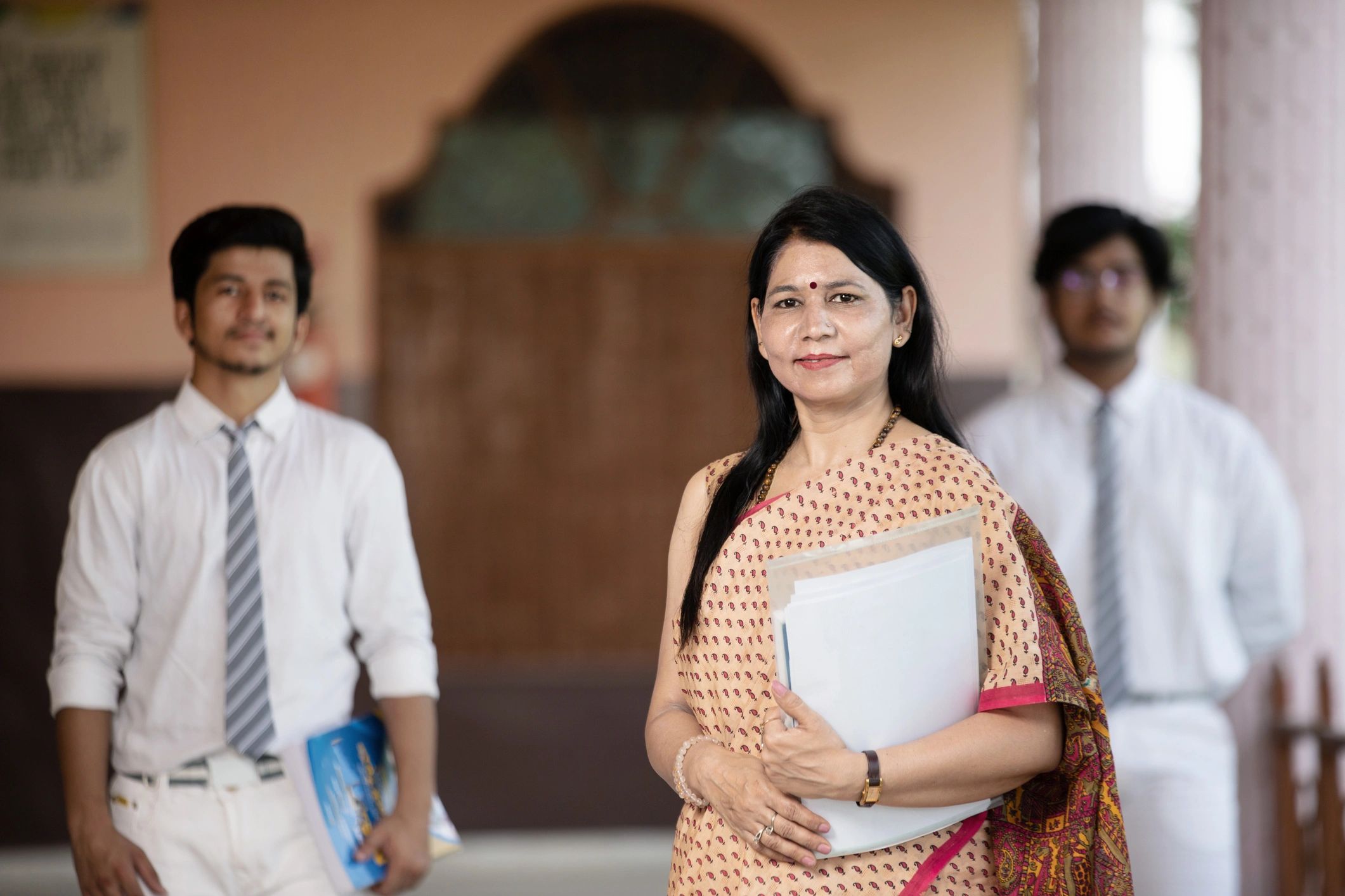 Confident Indian educator with students, representing empowering community development